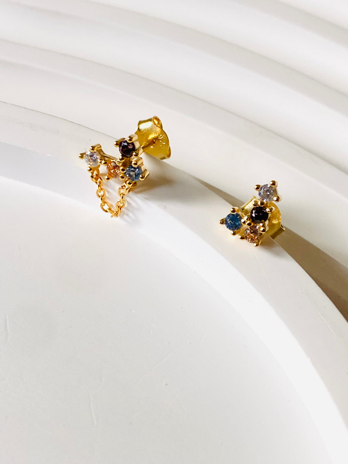 Back view of asymmetric multicolour stud earrings and butterfly backs