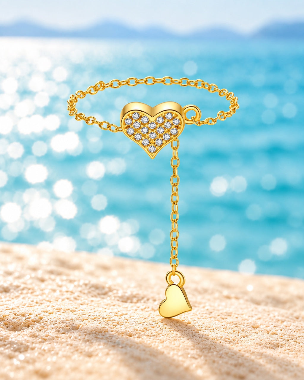 Gold pavé heart chain ring against turquoise lake