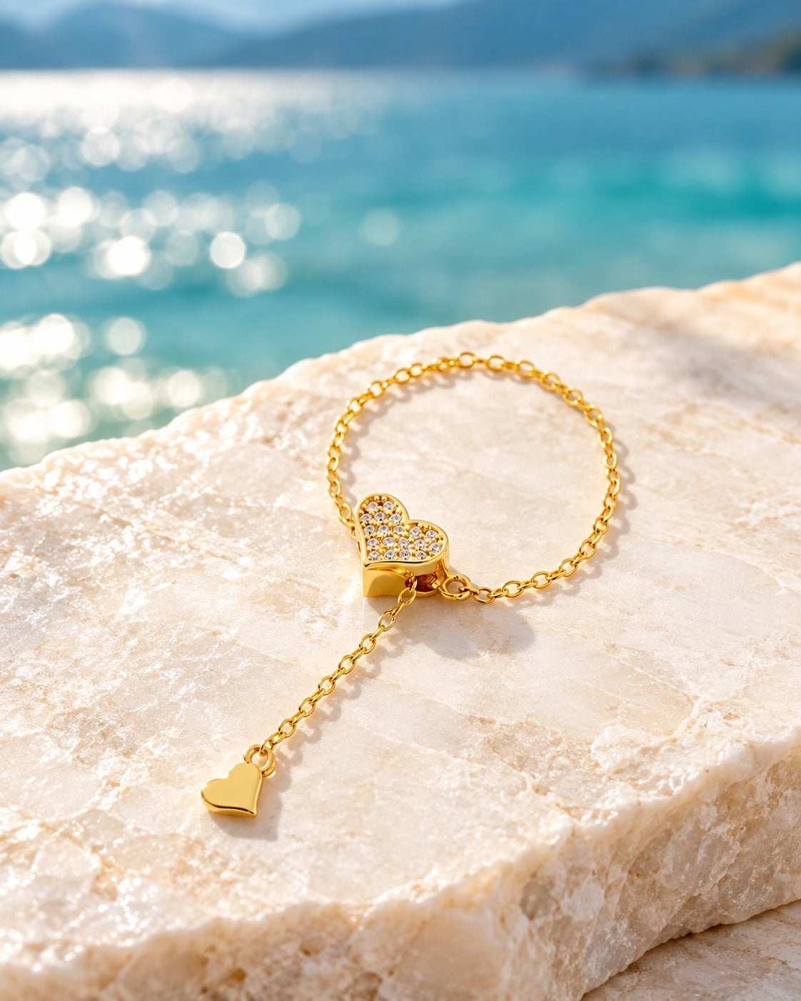 Gold heart chain ring on light stone by the lake