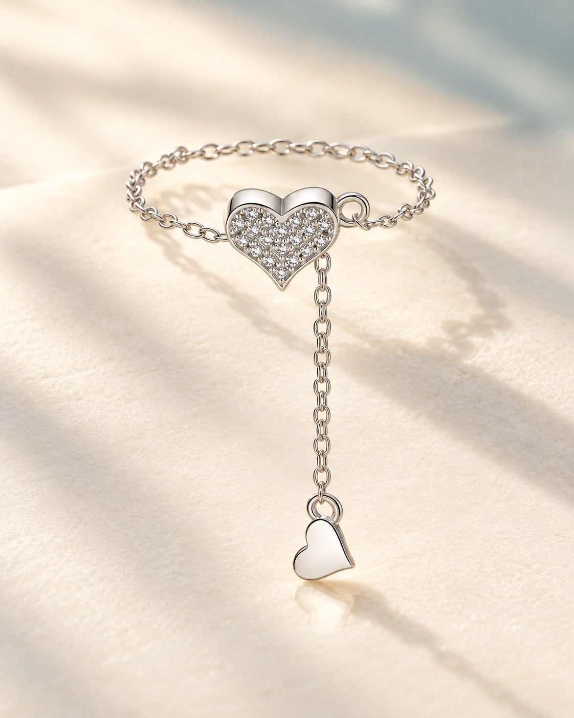 Silver pavé heart chain ring on ivory background
